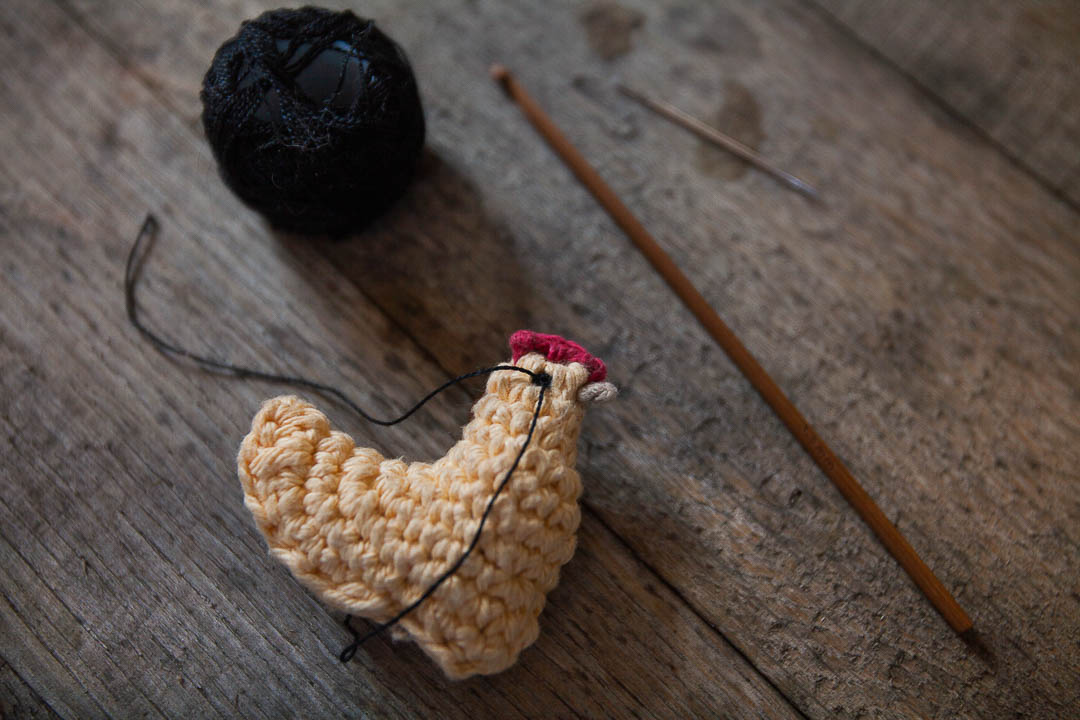 stitching the eyes of the chicken according to the crochet chicken pattern