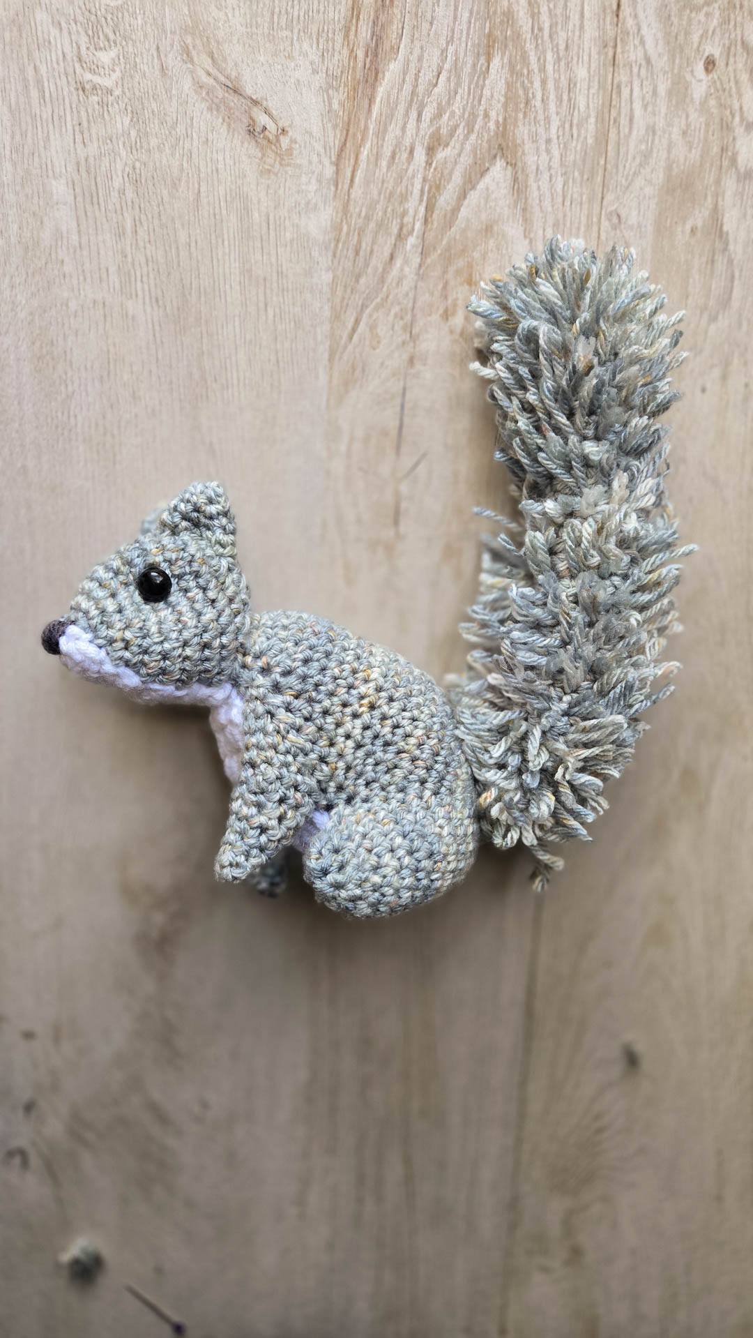 a pair of crochet pumpkins sitting in front of a decorative wooden lantern