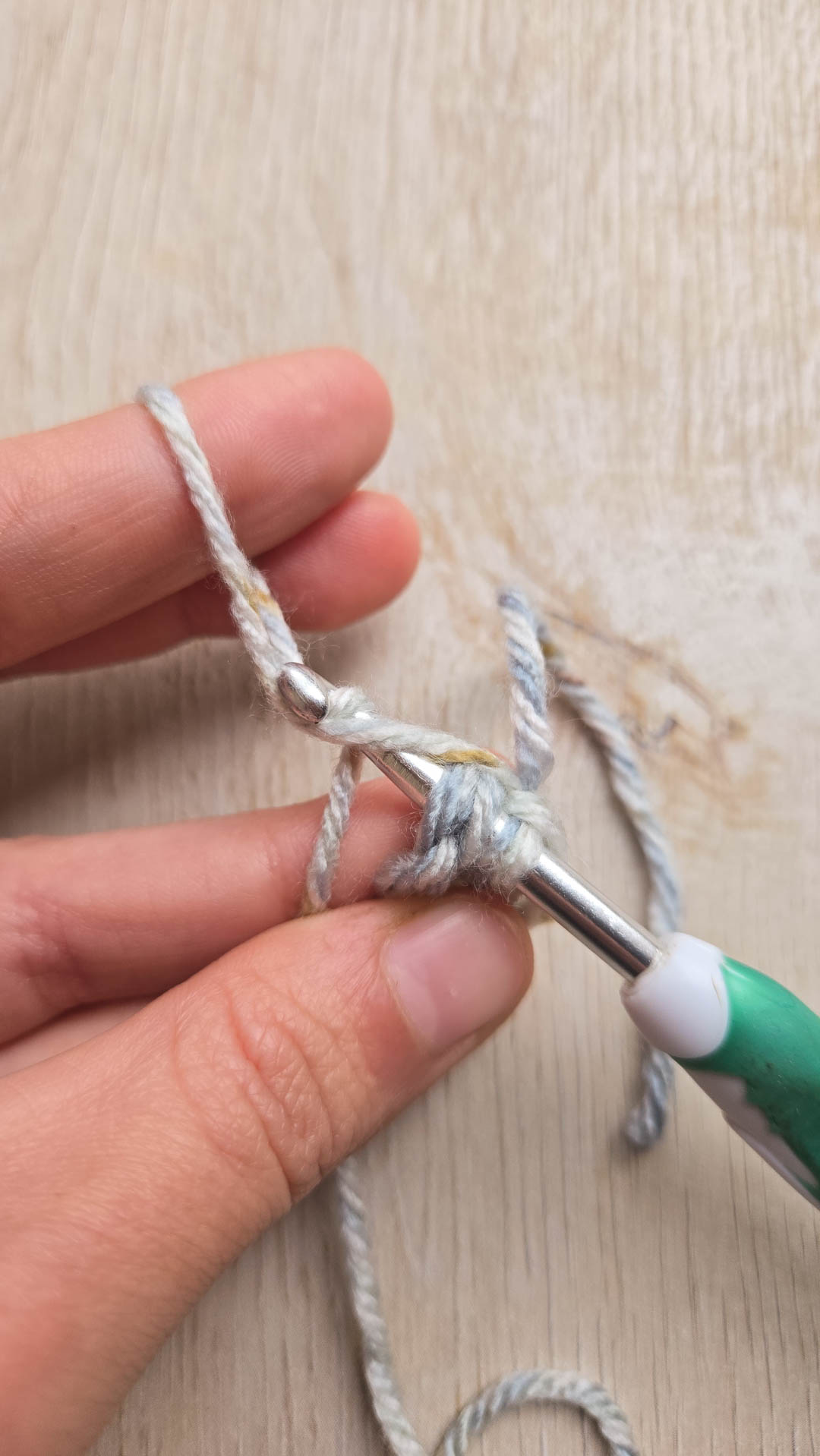 a hand demonstrating a crochet loop stitch in order to crochet fur