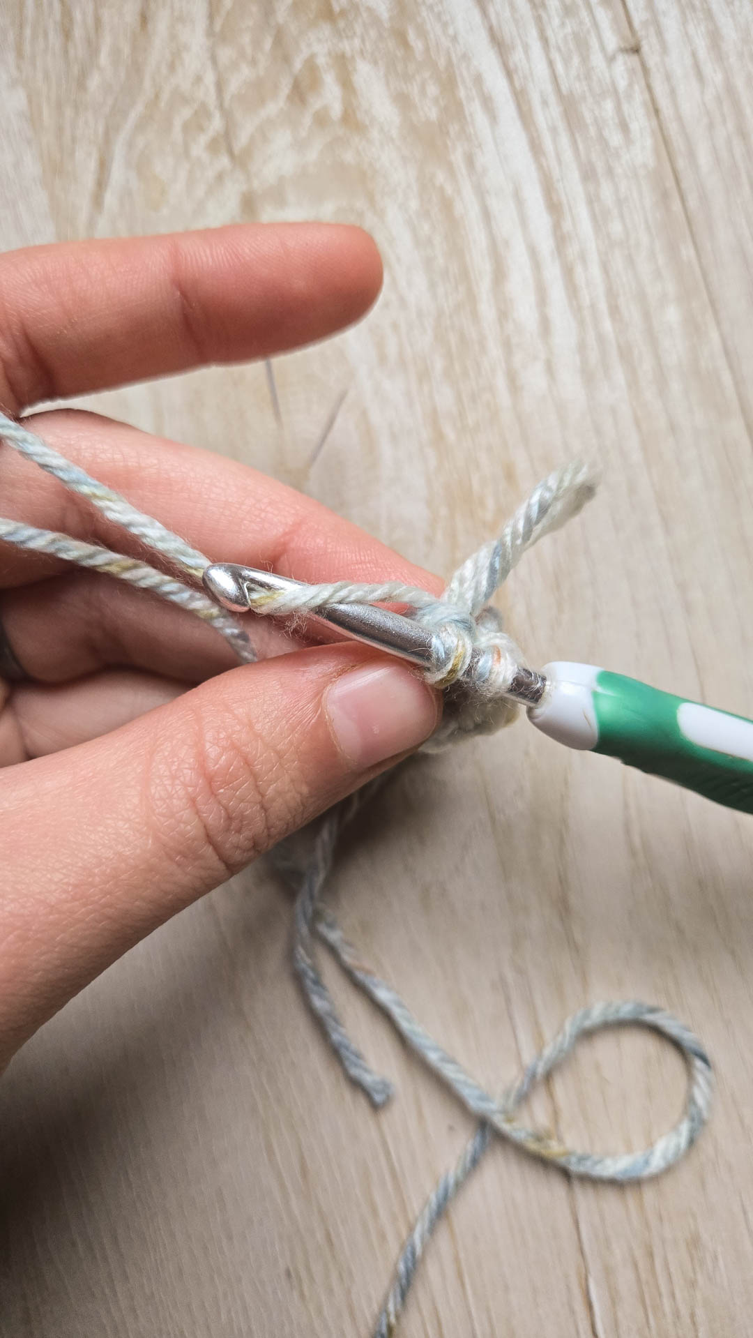 a hand showing how to make a loop stitch for learning how to crochet fur