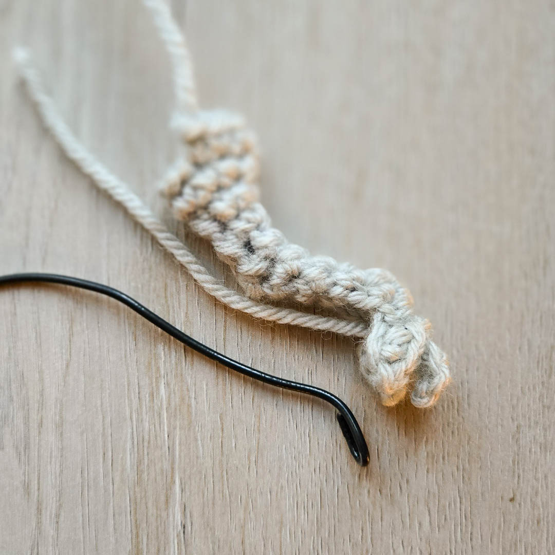 A crochet clawed arm with wire beside it.
