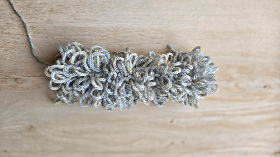 A grey crochet tail made with lots of crochet loop stitches.