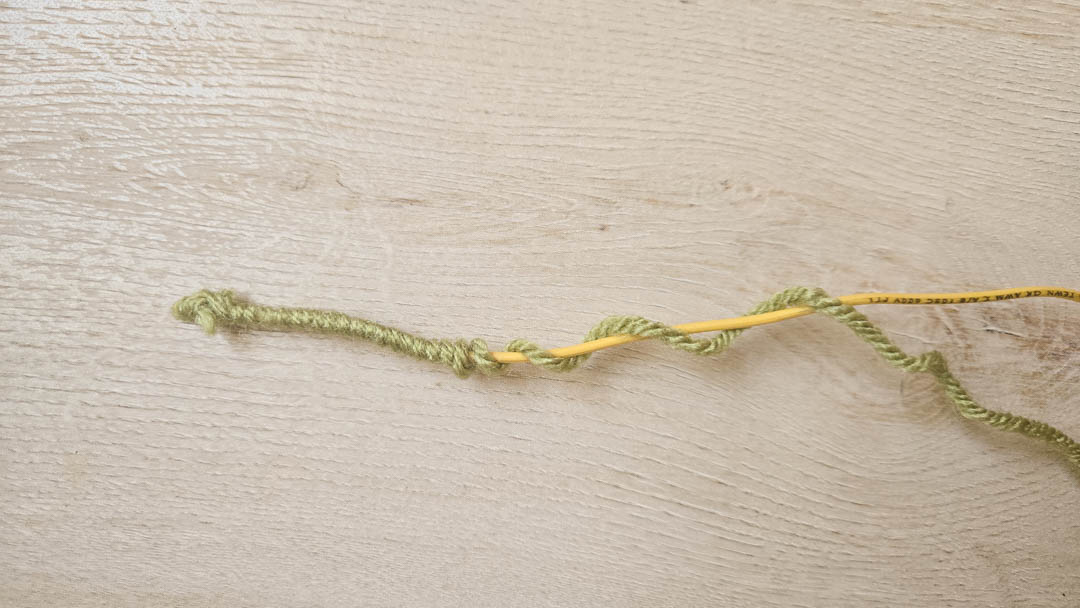 A crochet magic circle with a crochet hook, the start of the daffodil crochet pattern.