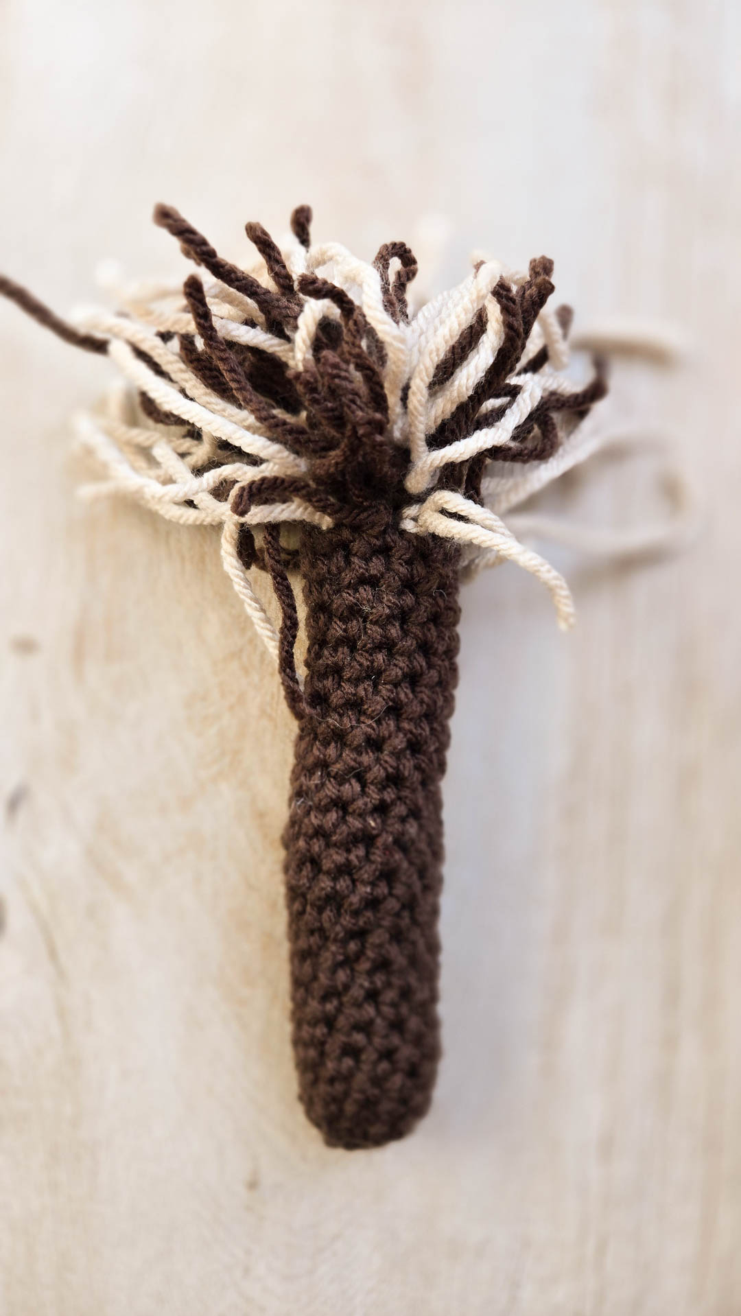 A crochet item covered with threads on one side, resembling crochet fur.